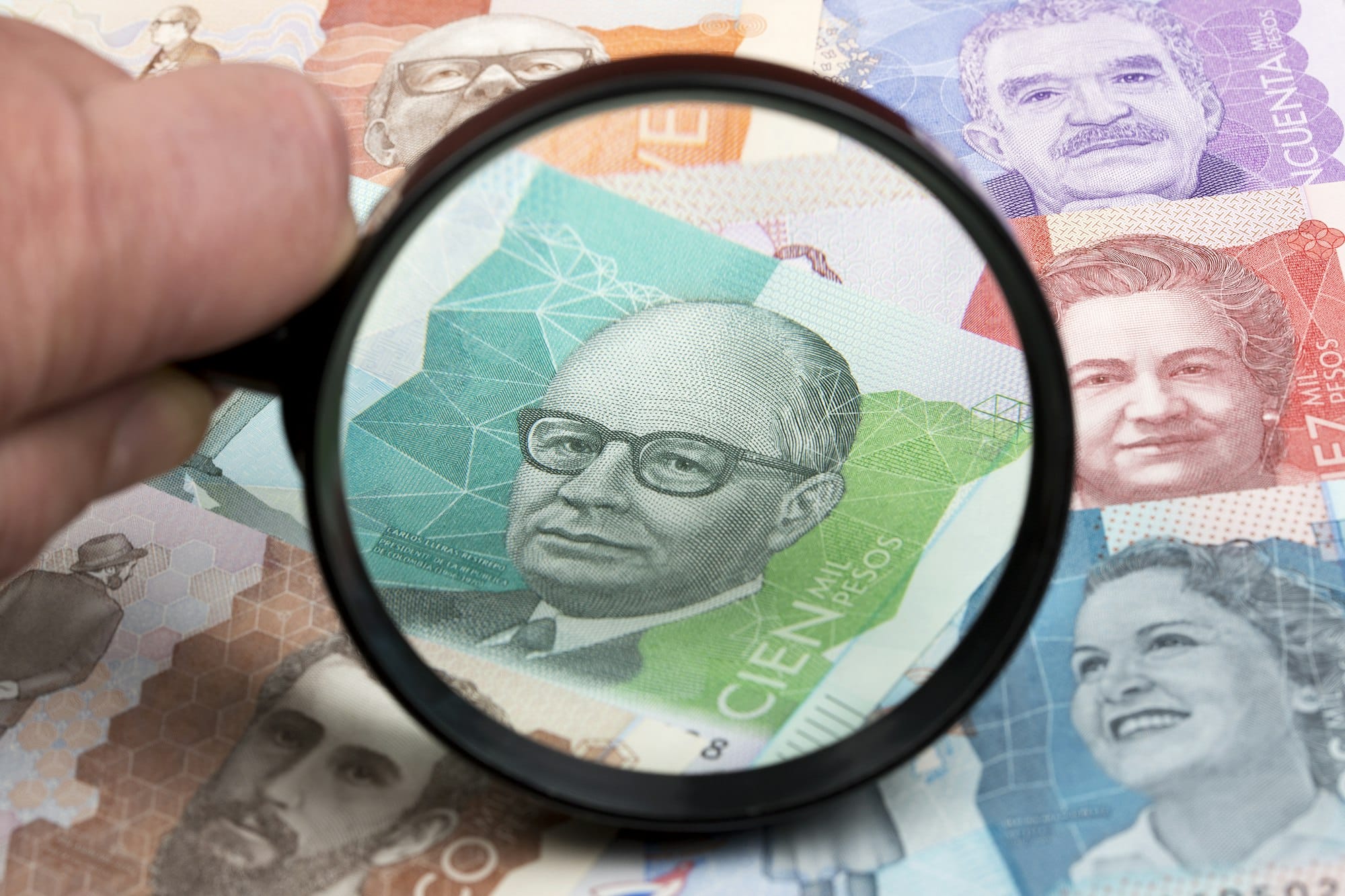 Colombian peso in a magnifying glass