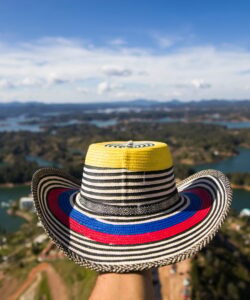 Hand with Colombian hat over Guatape lake in Antioquia, Colombia